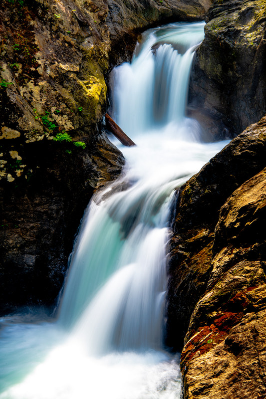 Close long exposure of Middle Falls cascading between golden-lit rock walls